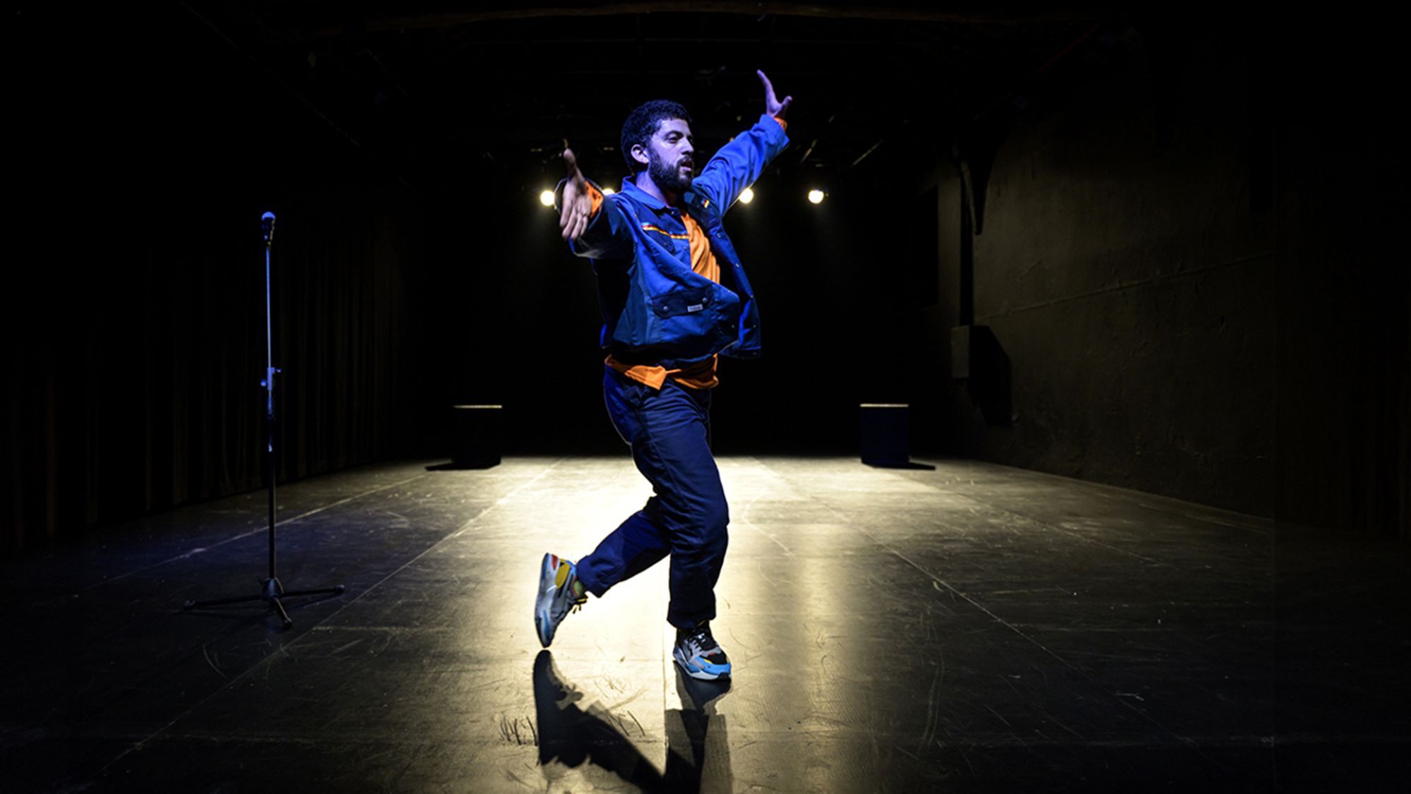 | | Pedro Sardinha Ein Mensch tanzt. Er wird von hinten angeleuchtet. Hintergrund und Boden sind schwarz.