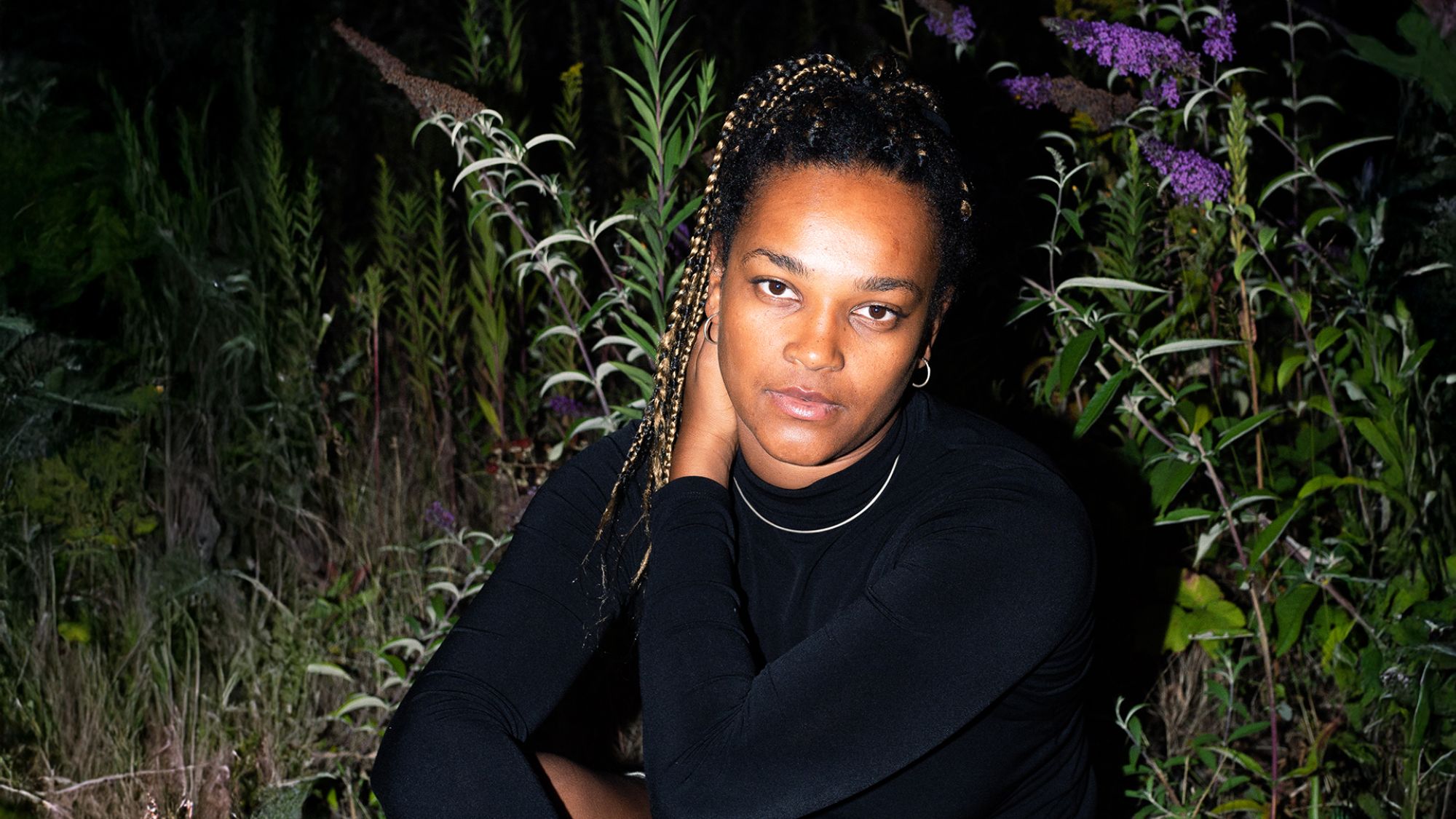 | | Vanessa Fengler Eine Frau sitzt auf einer Wiese und schaut in die Kamera.