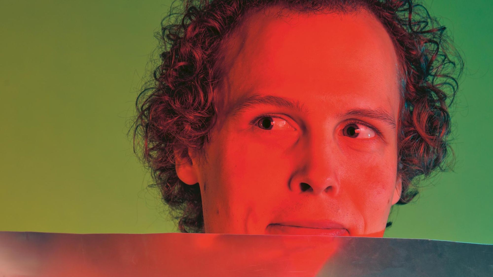 | | HfK: Berderow, Kirchner, Ölker Eine Person mit lockigem Haar schaut an der Kamera vorbei. Die Mundwinkel sind zu einem Lächeln angesetzt.