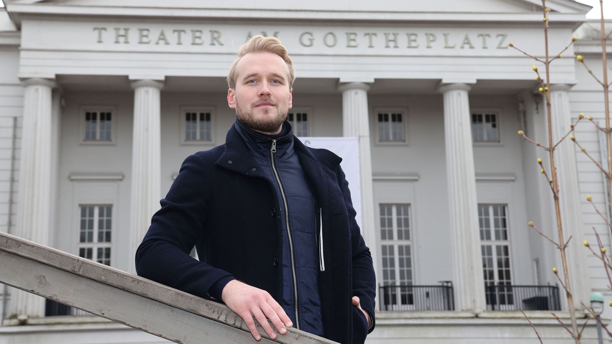 | | Ein Mann steht vor dem Theater am Goetheplatz.