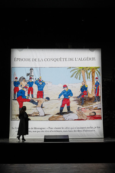 Hélène betrachtet ein Illustration, die die Gräuel der Niederschlagung des Algerienaufstandes darstellt.