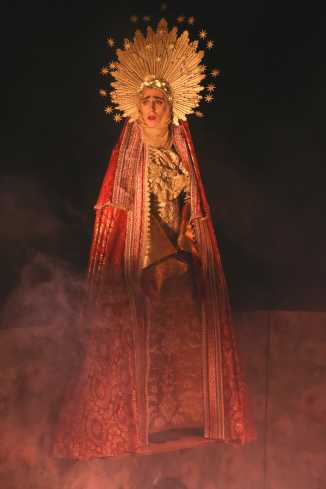 Ein Schauspieler in einem Madonnenkostüm mit goldenem Heiligenschein um den Kopf. 