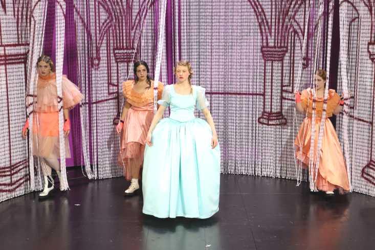 Vier Schauspielerinnen in grellfarbenen Kostümen stehen auf der Bühne. Ihre Kleider erinnern an die Kleidung im 19. Jahrhundert.