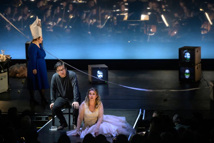 TITLE: Aida
URHEBER: Bettina Stöß Radames hat sich die Zeitungsausrisse vom Pullover genommen und sitzt wieder bei Aida, im Hintergrund der Verzweiflung nahe Amneris.