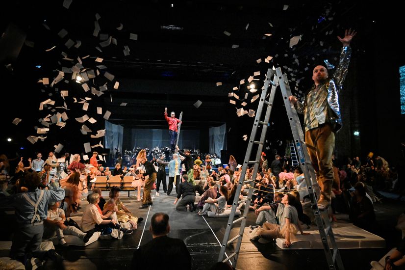 TITLE: Aufstieg und Fall der Stadt Mahagonny
URHEBER: Thomas Aurin Nach dem Hurrikan mischt Jimmy die Stadt Mahagonny auf. Es fliegen Flugblätter von Leitern.