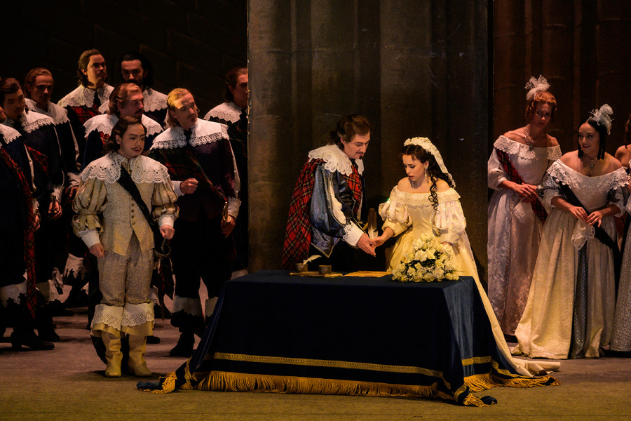 Von links tritt Arturo auf, während Lucia unter den Augen ihres Bruders Enrico den Ehevertrag unterzeichnet.