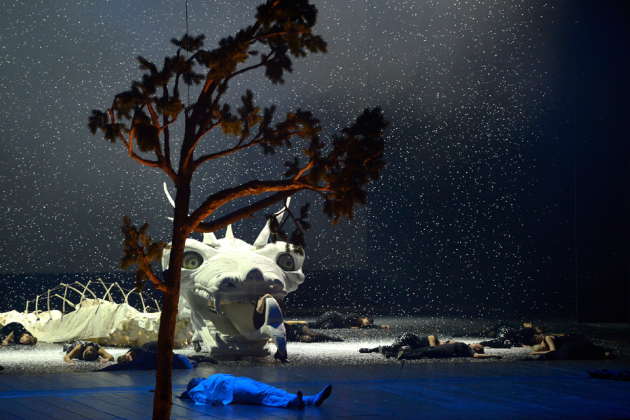 Die Zauberflöte - © Bettina Stöß Vor nachtblauem Bühnenhorizont schneit es. Auf dem Boden liegt die getötete Schlange, vor ihr ohnmächtig Tamino.