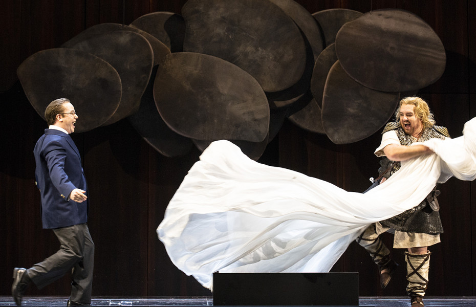 Götterdämmerung - © Bernd Uhlig Gunther und Siegfried schließen Freundschaft. Gunther in Alltagskleidung mit Sakko und Hemd, Siegfried in seinem mittelalterlichen Kostüm mit dem weißen Tuch, das er neben sich wehen lässt.