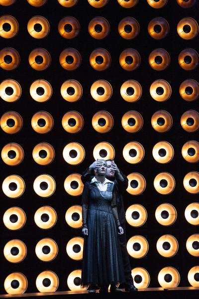 Tristan und Isolde -   © Bernd Uhlig  Tristan tritt hinter Isolde hervor. Er scheint, ihr die Augen zuhalten zu wollen.