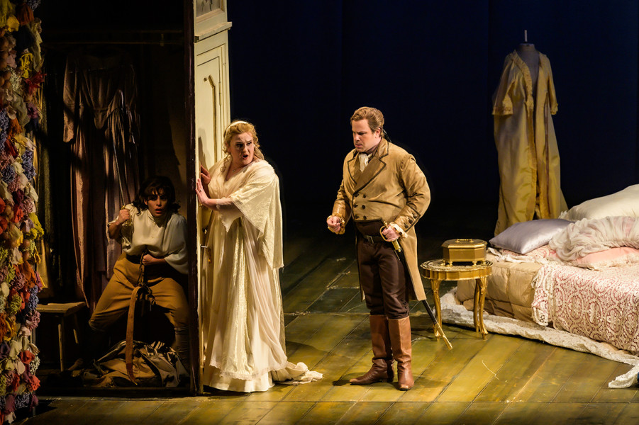 Le nozze di Figaro - © Bettina Stöß Cherubino ist versteckt in der Ankleidekammer der Gräfin. Almaviva ist ins Schlafgemach seiner Gattin gekommen und möchte eifersüchtig in die Kleiderkammer eindringen. Seine Gattin verwehrt ihm dies.
