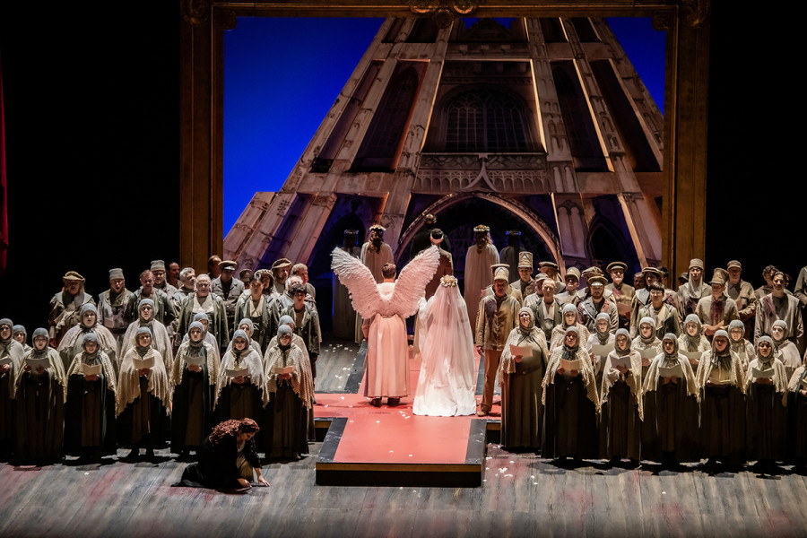 Lohengrin - © Bettina Stöß Lohengrin und Elsa schreiten als Brautpaar zum Münster. Ortrud bleibt abseits.