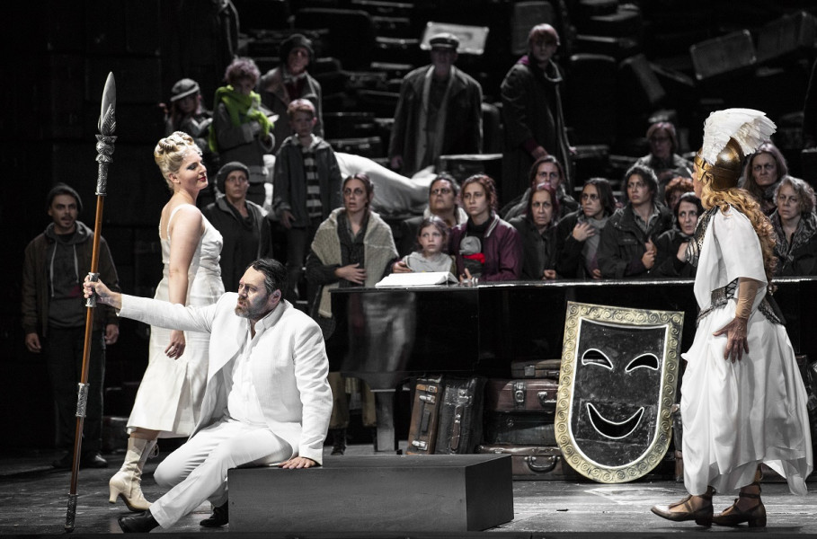 Die Walküre - © Bernd Uhlig Fricka verlangt von Wotan, Siegmund im Kampf mit Hunding zu fällen, und befiehlt ihm, Brünnhilde als Instrument gegen seinen Willen zu nutzen. Wotan sitzt ermüdet auf dem Souffleurkasten, Fricka (ohne ihren weißen Mantel) steht herausfordernd und siegesgewiss hinter ihm, seitlich steht Brünnhilde, fragend, zweifelnd.