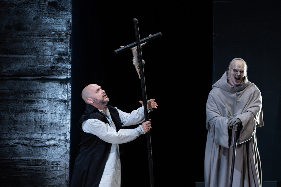 Don Carlo - © Marcus Lieberenz Ist Philipp wohl Herrscher in seinem Land, muss er sich doch unter die erbarmungslose Macht des Großinquisitors beugen. Wutverzerrt steht hinter Philipp, der ein Büßerkreuz in den Händen hält, der Großinquisitor. Der Großinquisitor fordert den Tod Rodrigos als Kopf der flandrischen Revolte.