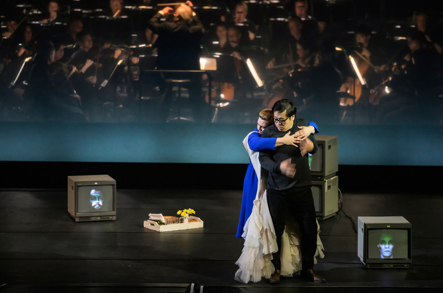 Aida - © Bettina Stöß Amneris hat sich das Brautkleid umgelegt und ein Frühstückstablett mit Blumen vorbereitet. Zärtlich umarmt sie von hinten Radames in der Hoffnung, seine Liebe wiederzufinden.