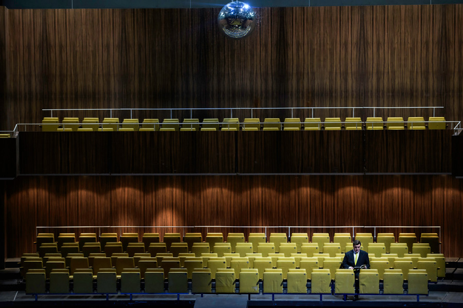 Rigoletto - © Bettina Stöß Völlig alleine sitzt der Gerichtsdiener im leeren gespiegelten Saal des Zuschauerraumes der Deutschen Oper Berlin. Er liest in einem Programmheft.