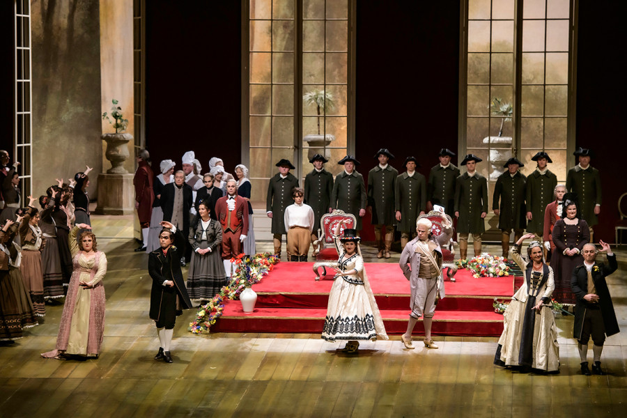 Es ist das große Hochzeitsfest. Die Solist*innen des Chores als Bäuerinnen und Bauern stehen an den Seiten im Hochzeitssaal. Drei Paare tanzen Fandango: Figaro mit der Gräfin, Susanna mit dem Grafen, Bartolo mit  Marcellina.