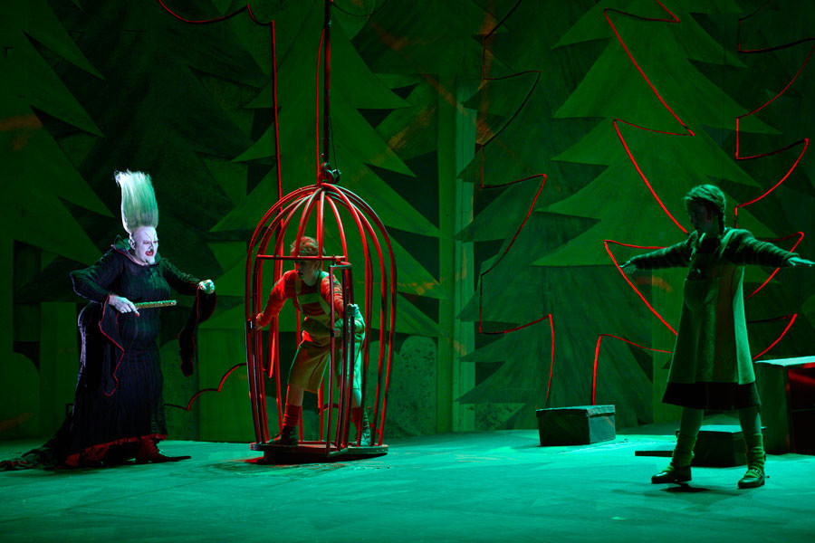 Hänsel und Gretel - © 2014 // Bettina Stöß Die Hexe verzaubert die beiden Kinder. Gretel kann sich nur noch marionettenhaft bewegen, und Hänsel geht in den Käfig, in dem er gemästet werden soll.