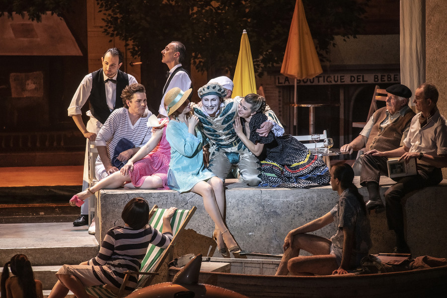 Il barbiere di Siviglia - © Bettina Stöß Auf diesem Bild ist eine Detailaufnahme vom rechten Mauervorsprung: Hier ist eine Kaffeehaus-Szenerie aufgebaut. Figaro in seinem Harlekinkostüm flirtet mit den Mädchen am Strand.
