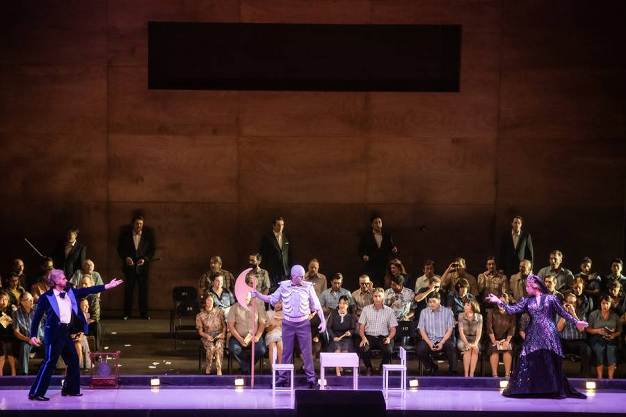 Turandot - © 2023 // Bettina Stöß Die drei Minister Ping, Pang und Pong spielen dem wartenden Volk die Köpfungszeremonie vor: Pang trägt ein Kostüm, das mit dem Gerippe an den Tod gemahnt, er trägt ein Beil. Ping trägt, einem Bewerber gleich, einen Anzug, Pong trägt ein schwarzes Kleid und ein Diadem, so Turandot zitierend.