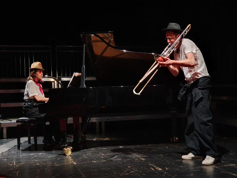 Auf dem Foto zwei Musiker*innen: eine Pianistin und ein Posaunist im Rahmen der Produktion Das Pustlangziehzupfkitzel-Orchester