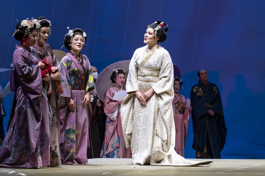 Madama Butterfly - © Bettina Stöß Cio-Cio-San umgeben von Freundinnen. Die Geisha trägt einen typischen japanischen Kimono in weiß, ihre Freundinnen in Lavendeltönen.
