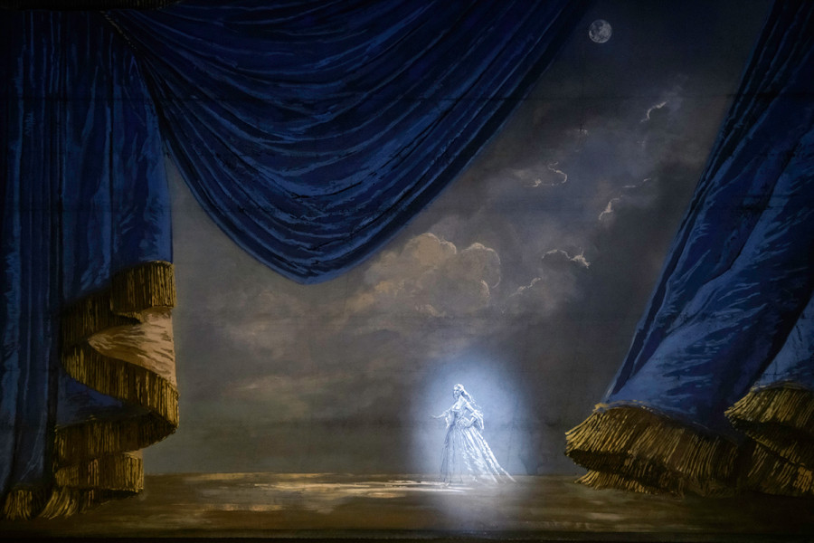 Bevor die Oper beginnt, verschließt dieser bemalte Prospekt die Bühne. Von Mondlicht beschienen wandelt Lucia di Lammermoor durch eine ideale romantische Landschaft. Schwere geraffte Vorhänge versinnbildlichen einen "Theatervorhang".