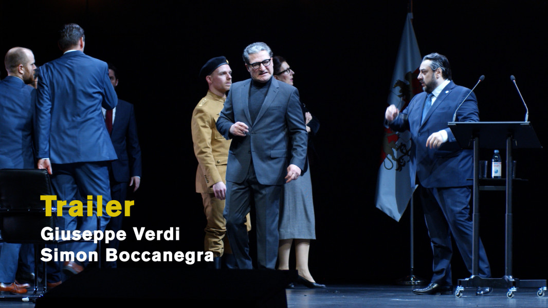 Giuseppe Verdi: Simon Boccanegra - © Ruth Tromboukis Auf diesem Standbild zum Videotrailer mit Stückimpressionen steht von Neid verzerrt Paolo Albiani. Hinter ihm Simon Boccanegra.