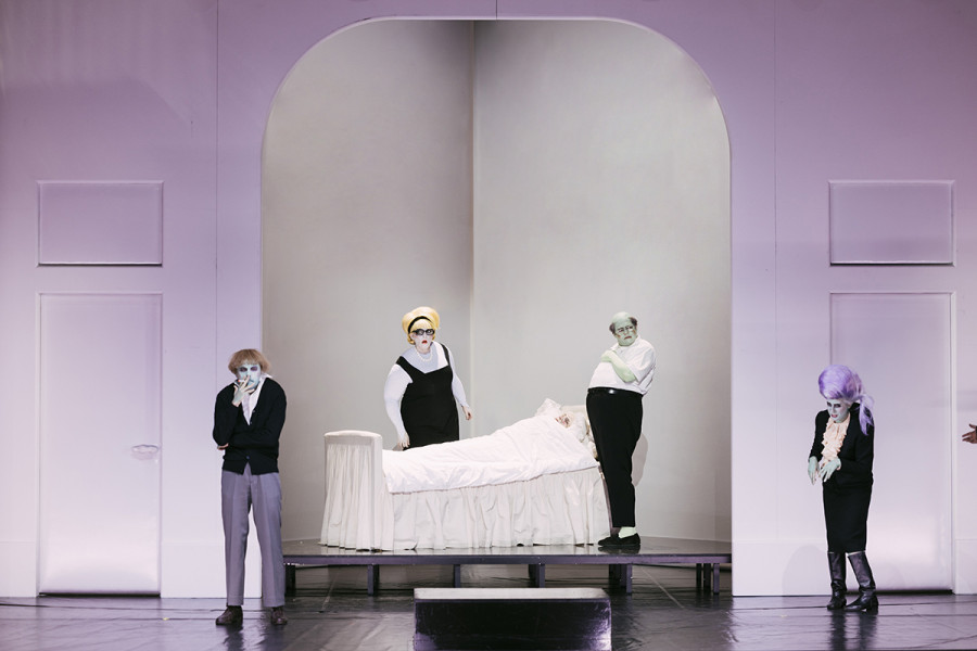 Il trittico - © Eike Walkenhorst Die Darsteller*innen haben grün oder gelb geschminkte Gesichter und Hände. Die Kostüme sind schwarz/weiß. Die Verwandtschaft - Marco, Zita, Simone, Nella - umstehen das Bett des Buoso Donati