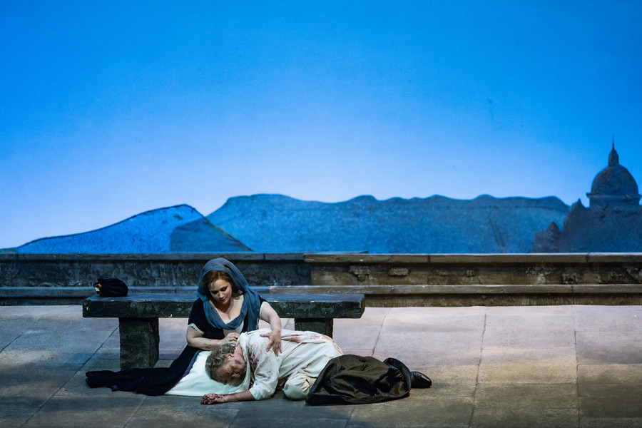 Tosca - © 2023, Bettina Stöß In der Morgendämmerung sind Tosca und Cavaradossi auf dem Dach der Engelsburg. Cavaradossi schmiegt den Kopf auf Toscas Knie. Sie breitet die Hände zärtlich über seine Schultern.