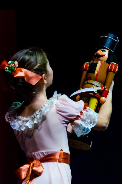 Kinder tanzen: Der Nussknacker - © Yan Revazov / KBKB Klara hält den Nussknacker, ihr Weihnachtsgeschenk, in der Hand und betrachtet ihn stolz.