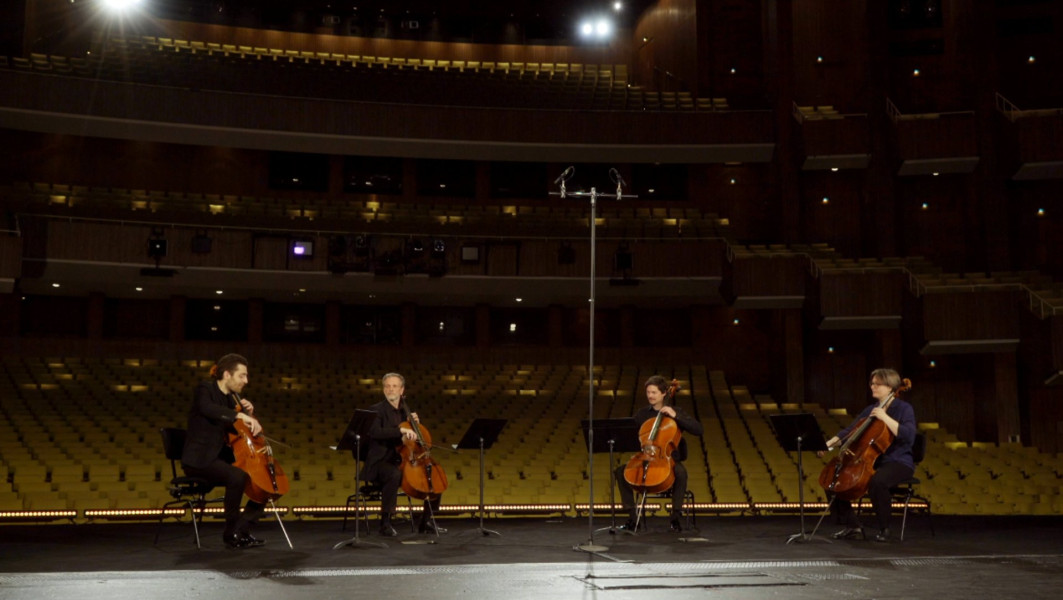 Dieses Bild ist das Standbild zu einem Video mit einem kammermusikalischen Medley aus Humperdincks HÄNSEL UND GRETEL. Die vier Cellist*innen Arthur Hornig, Johannes Petersen, Ulrike Seiffert und Stephan Buchmiller sitzen mit dem Rücken zum leeren Zuschauerraum.