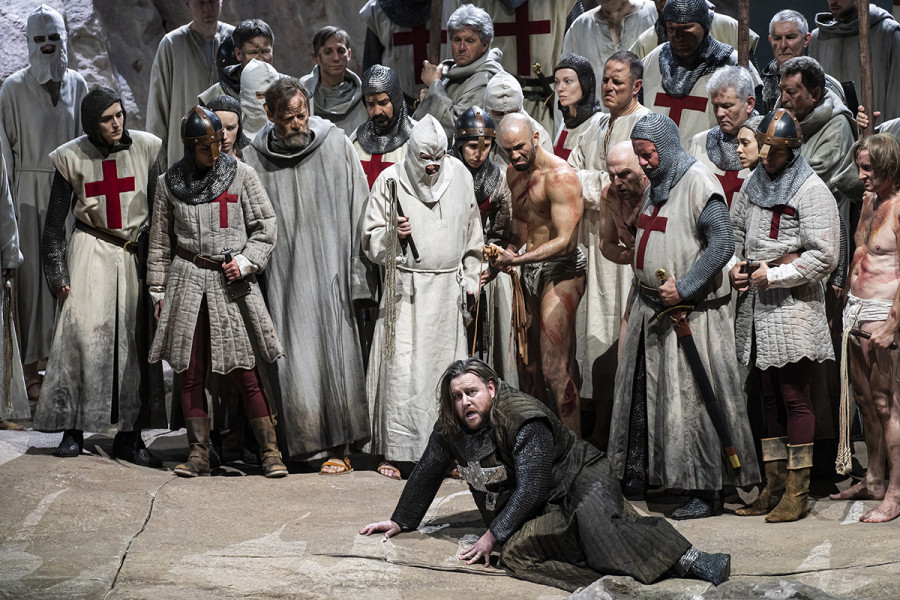 Parsifal - © Bettina Stöß Von Schmerz und Leid geplagt, kniet Amfortas auf dem Boden. Die Kreuzritter bedrängen ihn, den Gral zu enthüllen.
