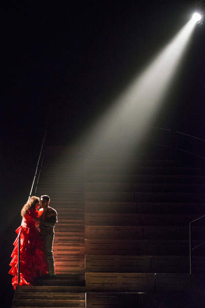 Carmen - © Marcus Lieberenz Carmen und Don José umschlungen im Arena-Rund. Ein einzelner Scheinwerfer beleuchtet sie punktartig und hebt sie aus dem Dunkeln.