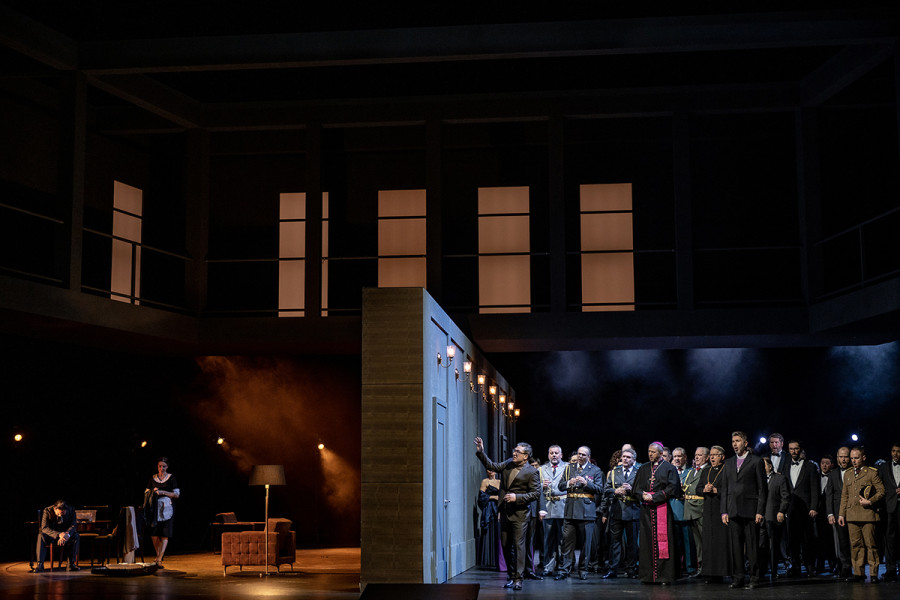 Simon Boccanegra - © Bettina Stöß Die Wand teilt nun den Bühnenraum. Links das Privatgemach Jacopo Fiescos, rechts der öffentliche Versammlungsraum mit dem Chor in Galauniformen und Abendroben.