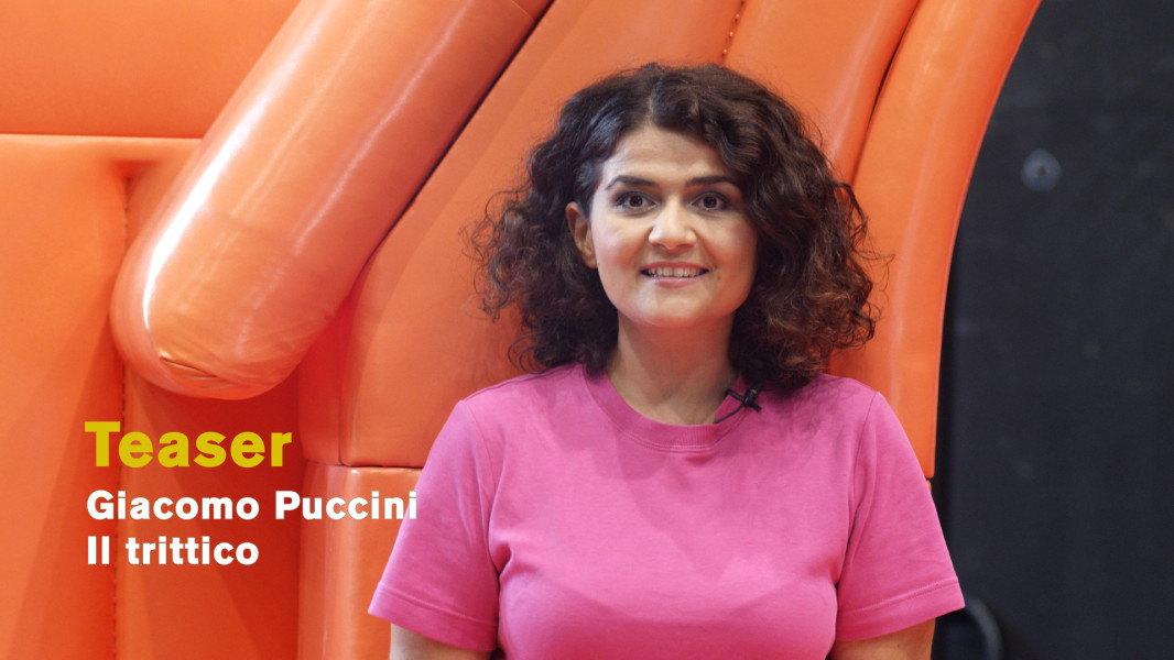 Die Regisseurin Pınar Karabulut spricht über die neue Produktion von IL TRITTICO. Sie steht dabei vor einer orangefarbenen stilisierten Kirche, ein Teil ihres Bühnenbildes. Im Verlaufe des Videos werden jeweils zu den Werken und Figuren die Kostümskizzen über schwarzem Hintergrund eingeblendet.