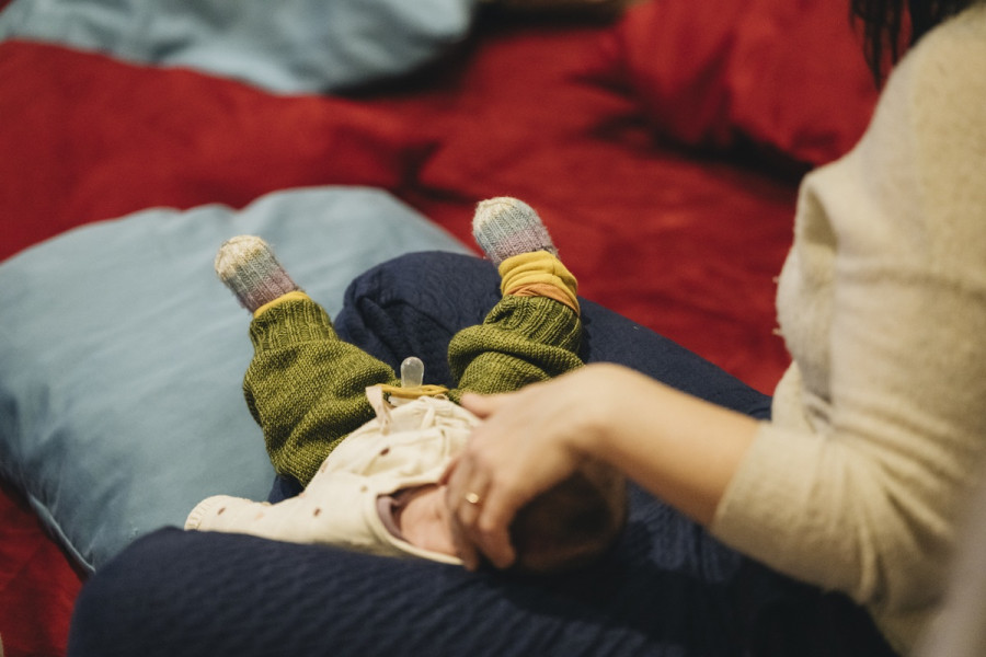 Babykonzert - © Nancy Jesse Ein Baby in den Armen seiner Mutter auf einem Sitzkissen.