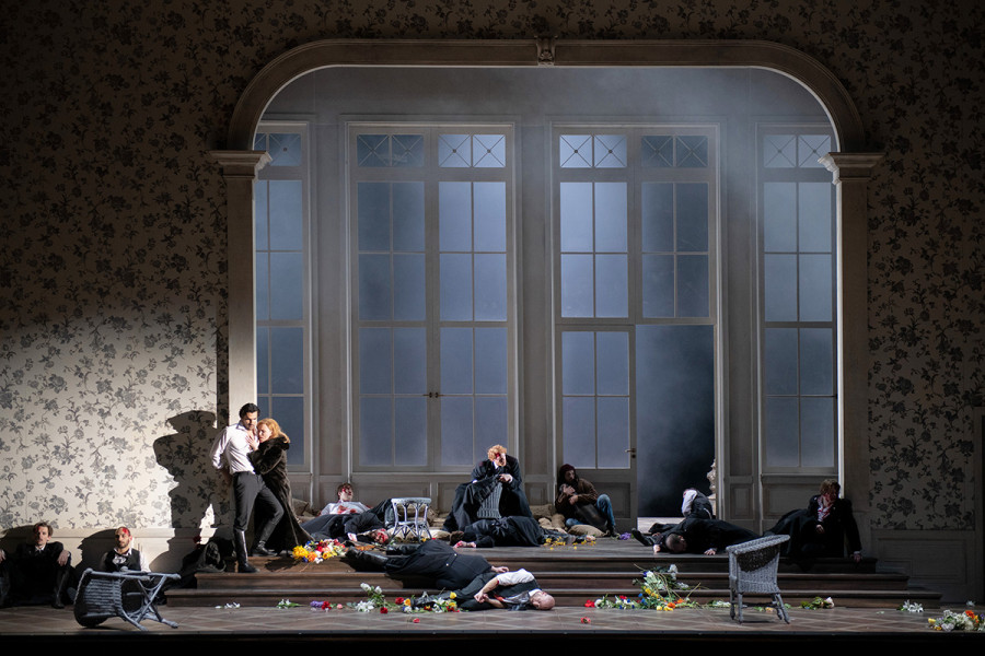 Francesca da Rimini - © Monika Rittershaus Der Bürgerkrieg ist in der Stadt angekommen. Auf den Treppenstufen liegen Leichen. Francesca schmiegt sich in einer Nische an Paolo il Bello. Hinter den hohen Glasfenstern ist Qualm, der auch in den Raum eindringt.