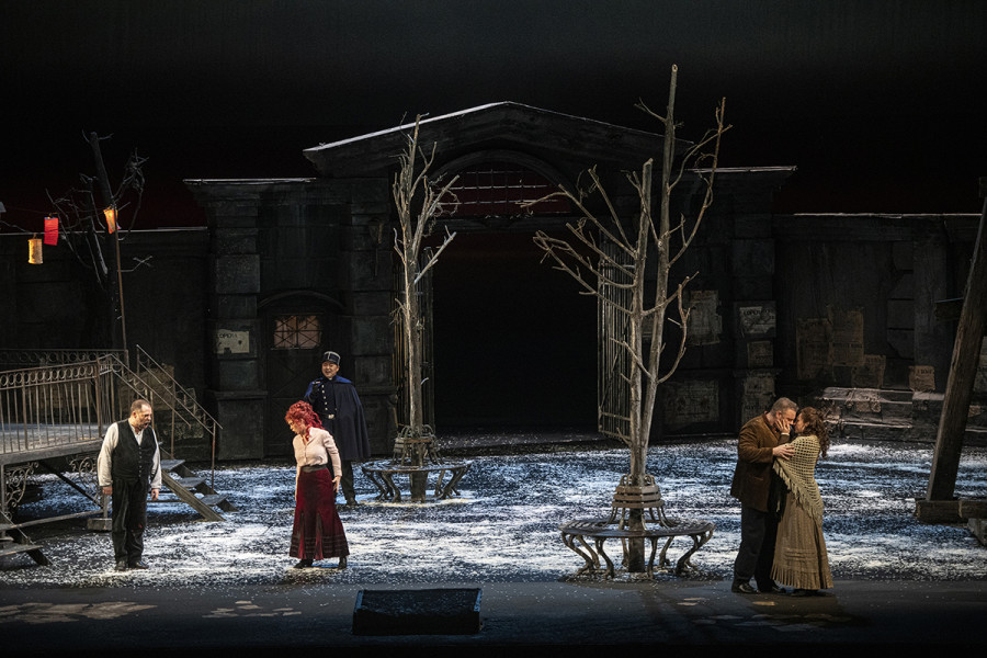 La Bohème - © Bettina Stöß Vor dem Gasthof an der Barrière d'enfer streiten sich links Musetta und Marcello wegen Marcellos üblicher Eifersüchteleien, rechts stehen einträchtig beieinander Rodolfo und Mimì.