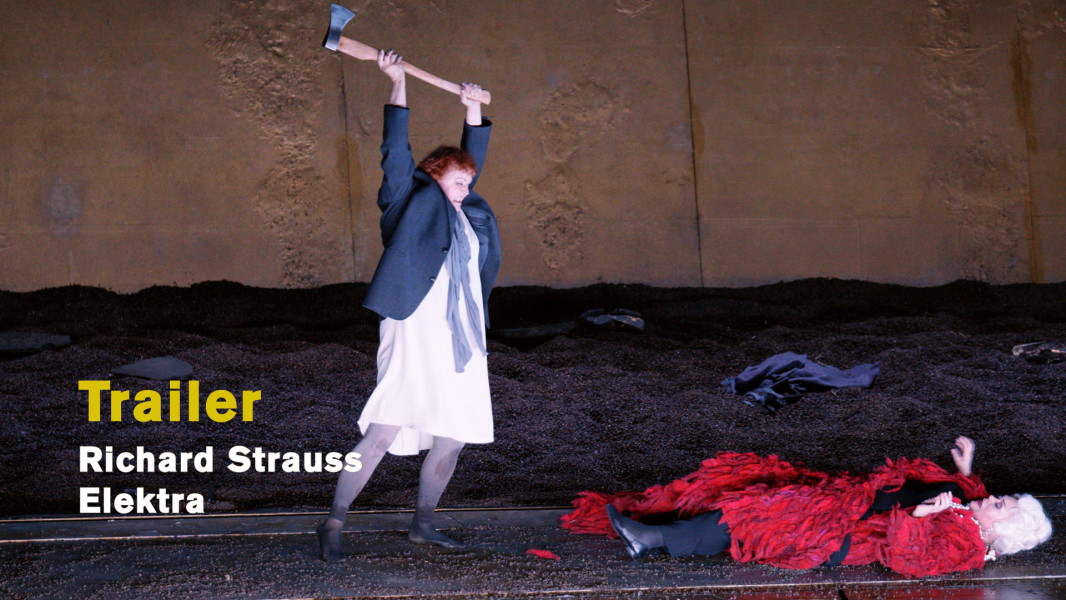 Richard Strauss: Elektra - © Ruth Tromboukis Dieses Foto ist das Standbild zum Video-Trailer mit Szenenimpressionen aus Kirsten Harms' Inszenierung zu ELEKTRA. Mit erhobenem Beil steht Elektra über ihrer Mutter, die zu Boden gestürzt ist. Klytämnestra trägt einen blutroten Mantel und zahllose Ketten.