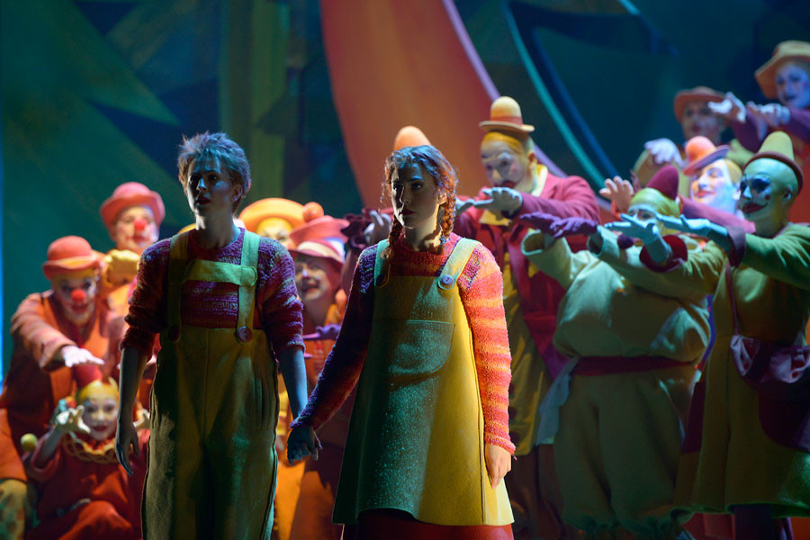 Hänsel und Gretel - © 2014 // Bettina Stöß Hand in Hand stehen Hänsel, den Blick in die Ferne gerichtet. Um sie die Clowns. Bald ist die Nacht vorbei.