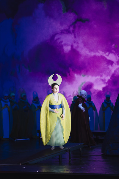 Suor Angelica - © Eike Walkenhorst Vor einem dramatischen, lilafarbenen Himmel steht Suor Angelica in ihrem goldgelben Mantel.
