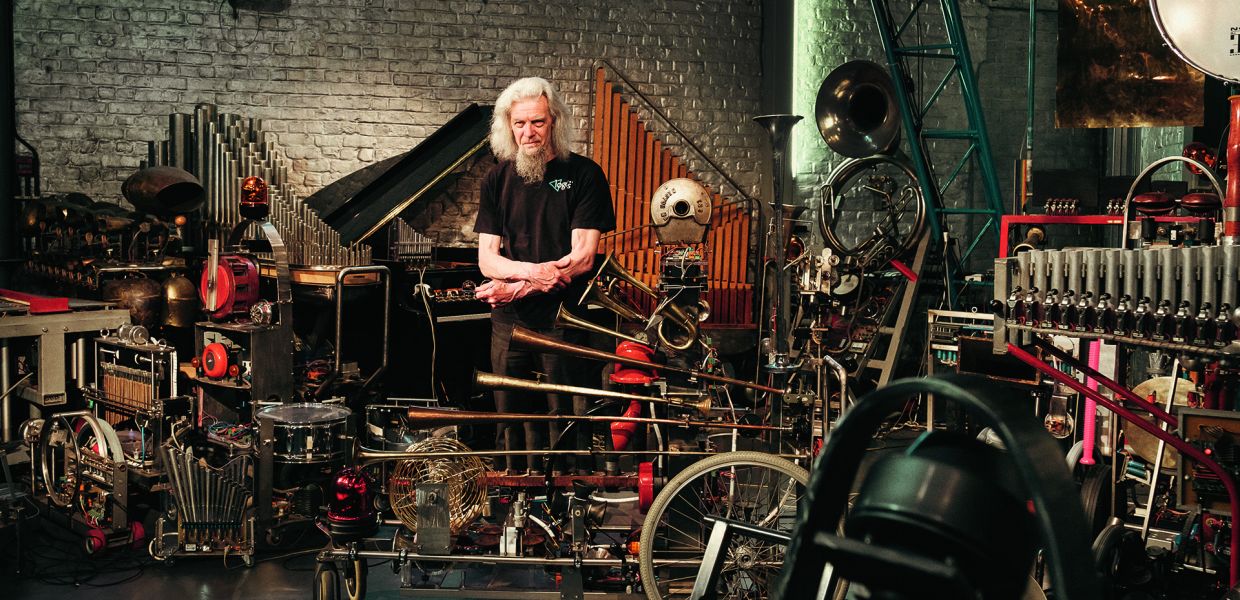 Raes inmitten des Roboterorchesters: Vor ihm steht auf Rädern seine neueste Erfindung, der »Rumo«, benannt nach dem italienischen Futuristen Luigi Russolo © Sarah Bastin  Raes inmitten des Roboterorchesters: Vor ihm steht auf Rädern seine neueste Erfindung, der »Rumo«, benannt nach dem italienischen Futuristen Luigi Russolo © Sarah Bastin