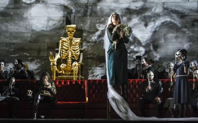 Auf dem Bild eine Szene aus David Aldens ANNA BOLENA, auf dem Königsthron sitzt der Tod.