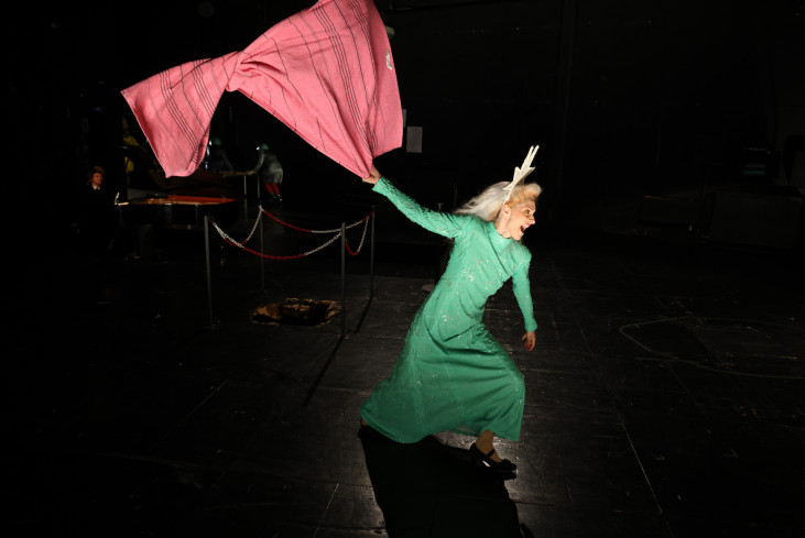 Eine Schauspielerin in einem grünen Kleid mitten im Lauf. Sie schwenkt eine rote Decke. Eine Schauspielerin in einem grünen Kleid mitten im Lauf. Sie schwenkt eine rote Decke.