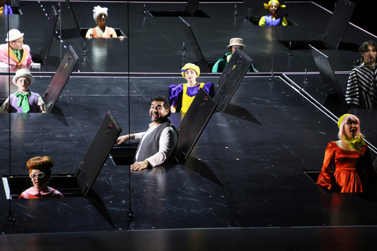In der Schwebebühne sind alle Klappen geöffnet und ein Solist und der Chor singen daraus.  In der Schwebebühne sind alle Klappen geöffnet und ein Solist und der Chor singen daraus.