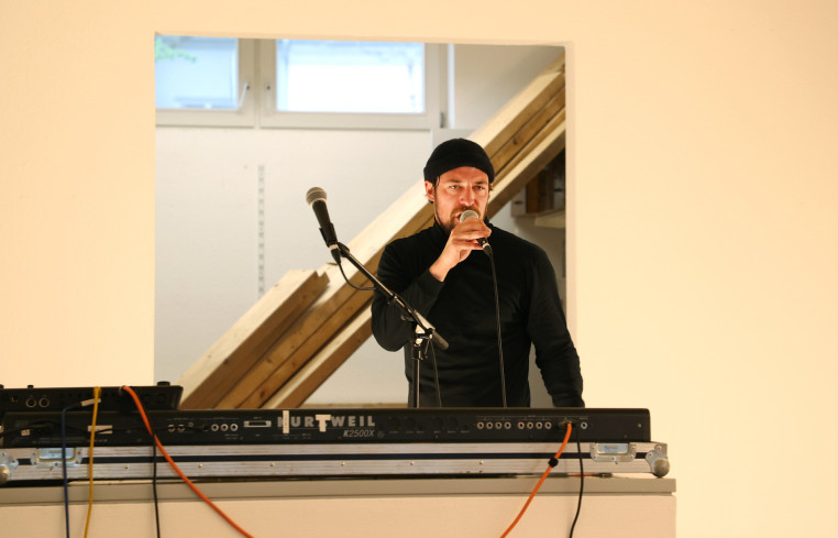 Ein Mann steht an einem Mischpult. Er singt in ein Mikrofon. Ein Mann steht an einem Mischpult. Er singt in ein Mikrofon.