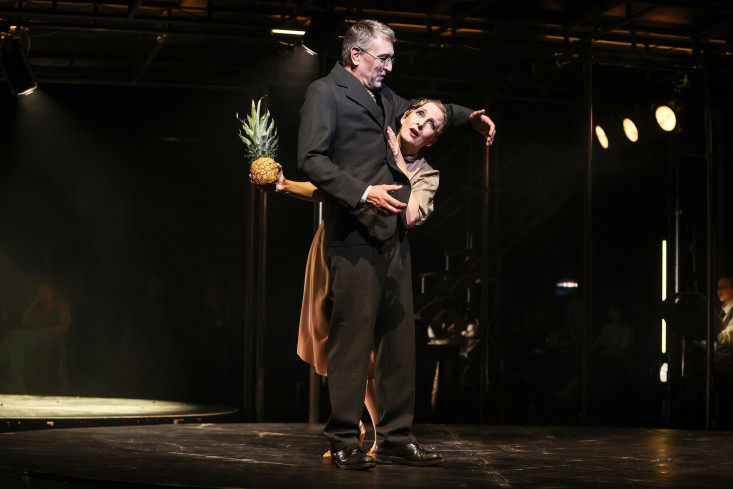 Eine Schauspielerin lehnt an einem Schauspieler. Sie hält eine Ananas in ihrer Hand. Eine Schauspielerin lehnt an einem Schauspieler. Sie hält eine Ananas in ihrer Hand.