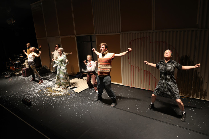 Sieben Personen stehen nebeneinander auf der Bühne. Alle machen die gleichen Bewegungen. Sie tanzen eine Choreografie. Sieben Personen stehen nebeneinander auf der Bühne. Alle machen die gleichen Bewegungen. Sie tanzen eine Choreografie.
