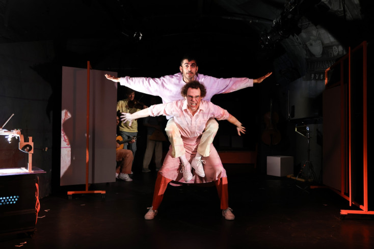 Eine Person trägt eine andere Person huckepack. Beide haben die Arme ausgebreitet. Eine Person trägt eine andere Person huckepack. Beide haben die Arme ausgebreitet.