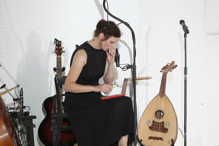 Eine Musikerin spielt auf einem kleinen Xylophon. Um sie herum stehen Instrumente. Eine Musikerin spielt auf einem kleinen Xylophon. Um sie herum stehen Instrumente.